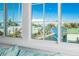Bedroom window view showcasing waterfront homes, docks, and lush palm trees against a blue sky at 401 20Th Pl, Bradenton Beach, FL 34217