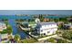 Beautiful white home with a balcony overlooking the water, complete with lush landscaping, and neighboring waterfront properties at 401 20Th Pl, Bradenton Beach, FL 34217