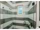 Modern shower featuring tiled walls, a window, a glass door, and sleek fixtures at 401 20Th Pl, Bradenton Beach, FL 34217