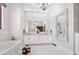 Elegant bathroom features a soaking tub, dual vanity, chandelier, and marble floor at 4205 Higel Ave, Sarasota, FL 34242