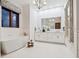 Spa-like bathroom with a soaking tub, double vanity, and a large mirror reflecting the chandelier's light at 4205 Higel Ave, Sarasota, FL 34242
