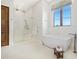 Bright bathroom featuring a modern tub, glass shower, and marble-look tile at 4205 Higel Ave, Sarasota, FL 34242