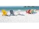 Colorful beach chairs arranged on the white sand, facing the calm ocean at 4205 Higel Ave, Sarasota, FL 34242