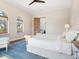 Sunny bedroom with arched windows, wood floors, and a comfortable bed at 4205 Higel Ave, Sarasota, FL 34242