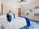 Well-lit bedroom with hardwood floors, plush bedding, and bright blue accents at 4205 Higel Ave, Sarasota, FL 34242