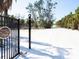 Private gated entrance leading to a serene property with sandy driveway at 4205 Higel Ave, Sarasota, FL 34242