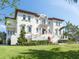 Stately Mediterranean-style home with a red tile roof, manicured lawn, and elegant entrance staircase at 4205 Higel Ave, Sarasota, FL 34242