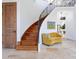 Elegant foyer features a curved staircase, wood door, sitting area and stone flooring at 4205 Higel Ave, Sarasota, FL 34242