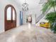 Grand foyer featuring tile floors, an arched doorway, a staircase, and a statement light fixture at 4205 Higel Ave, Sarasota, FL 34242