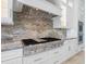 Modern kitchen featuring a Wolf gas range, custom cabinetry, and granite countertops at 4205 Higel Ave, Sarasota, FL 34242