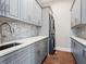 Laundry room with gray cabinets, modern appliances, and a mosaic tile backsplash at 4205 Higel Ave, Sarasota, FL 34242