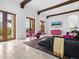 Living room with travertine floors, exposed wood beams, and access to the outdoor living area at 4205 Higel Ave, Sarasota, FL 34242