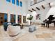 Bright, expansive living room with high ceilings, wood beams, piano, and stylish modern furnishings at 4205 Higel Ave, Sarasota, FL 34242
