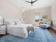 Bright bedroom features a blue patterned rug, sitting area, and ceiling fan at 4205 Higel Ave, Sarasota, FL 34242
