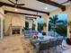 Inviting covered patio boasts a stone fireplace, comfortable seating, and serene waterfront views at 4205 Higel Ave, Sarasota, FL 34242