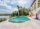 Stunning backyard pool with waterfront views, lush landscaping, and lounge chairs at 4205 Higel Ave, Sarasota, FL 34242