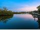 Scenic waterfront view featuring lush mangroves and serene water reflecting the pastel sky at twilight at 4205 Higel Ave, Sarasota, FL 34242