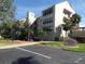 Exterior view of a modern multi-story building featuring lush landscaping, palm trees, and private signage at 4555 Bay Club Dr # 22, Bradenton, FL 34210