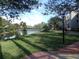 Scenic view of the community grounds with a pond, lush greenery, and walking path at 4555 Bay Club Dr # 22, Bradenton, FL 34210