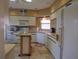 Bright kitchen featuring white cabinets, tiled floors, a window, and recessed lighting at 4555 Bay Club Dr # 22, Bradenton, FL 34210
