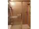 Close-up of shower with textured glass doors and brown tile walls at 4555 Bay Club Dr # 22, Bradenton, FL 34210