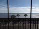 Beautiful water view through a window, with palm trees and a fence in the foreground at 4555 Bay Club Dr # 22, Bradenton, FL 34210