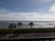 Serene water view with palm trees and a clear blue sky at 4555 Bay Club Dr # 22, Bradenton, FL 34210