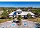Community clubhouse featuring ample parking, lush landscaping, and a covered entrance at 4706 Roycroft Ter, Parrish, FL 34219