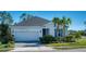 Charming single-story home with a two-car garage, palm trees and manicured lawn at 4706 Roycroft Ter, Parrish, FL 34219