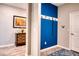 Hallway with wood flooring and a blue accent wall featuring a coat rack at 4706 Roycroft Ter, Parrish, FL 34219