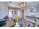 Bright home office featuring wood floors, a modern chandelier, and a rustic wood desk at 4706 Roycroft Ter, Parrish, FL 34219