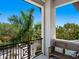 Outdoor balcony features a wooden bench with colorful pillows and a view of tropical foliage at 4940 Peaceable Way, Sarasota, FL 34242