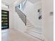 An elegant entryway features a modern front door and a staircase with decorative metal railings at 4940 Peaceable Way, Sarasota, FL 34242