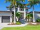 Two-story home with palm trees, well-manicured lawn, and two-car garage at 4940 Peaceable Way, Sarasota, FL 34242