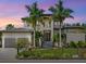 Stunning two-story home showcasing a meticulously landscaped front yard and modern architectural design at 4940 Peaceable Way, Sarasota, FL 34242
