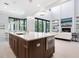 An open-concept kitchen boasts a large center island, pendant lighting, modern appliances and an adjacent living area at 4940 Peaceable Way, Sarasota, FL 34242