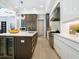 A well-equipped kitchen features a large island with a wine cooler, stainless steel appliances, and ample counter space at 4940 Peaceable Way, Sarasota, FL 34242