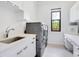 Bright laundry room with white cabinets, stainless steel sink, and modern washer and dryer at 4940 Peaceable Way, Sarasota, FL 34242