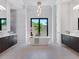 Beautiful main bathroom boasts a soaking tub with large window and dual vanities at 4940 Peaceable Way, Sarasota, FL 34242