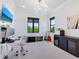 Bright office space with a desk, wall-mounted TV, and natural light from windows at 4940 Peaceable Way, Sarasota, FL 34242