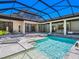 Backyard pool featuring a sun shelf, an outdoor kitchen, covered patio and lush landscaping at 4940 Peaceable Way, Sarasota, FL 34242