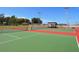 Well-maintained tennis courts with green and red surfaces and a sheltered bench for players at 4940 Peaceable Way, Sarasota, FL 34242