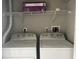 A well-equipped laundry area with washer, dryer, and overhead shelving for convenience at 5701 Bentgrass Dr # 18-203, Sarasota, FL 34235