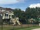 Community playground features slides and swings alongside residences and mature trees at 5701 Bentgrass Dr # 18-203, Sarasota, FL 34235