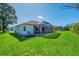 Spacious backyard featuring a screened-in lanai, lush lawn, and well-maintained landscaping at 5872 Mckinley Rd, Venice, FL 34293