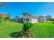 Expansive backyard with a well-maintained lawn, mature trees, and a screened-in lanai at 5872 Mckinley Rd, Venice, FL 34293