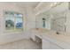 Bathroom with double sinks, a large mirror, and a window that provides natural light at 5872 Mckinley Rd, Venice, FL 34293