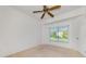 Bright bedroom featuring a ceiling fan and a window view of the landscaped yard at 5872 Mckinley Rd, Venice, FL 34293