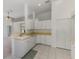 Bright kitchen featuring white cabinets and appliances, with views to living areas at 5872 Mckinley Rd, Venice, FL 34293