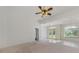 Expansive living room with carpet and tile flooring, offering views of the front yard through arched windows at 5872 Mckinley Rd, Venice, FL 34293